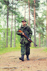 Image showing young soldier or hunter with gun in forest