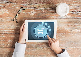 Image showing close up of hands with tablet pc and shopping cart