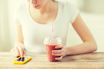 Image showing close up of woman with smartphone and smoothie