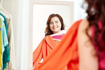 Image showing happy plus size woman with shirt at mirror