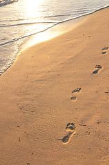 Image showing Footprints on sandy beach at sunrise