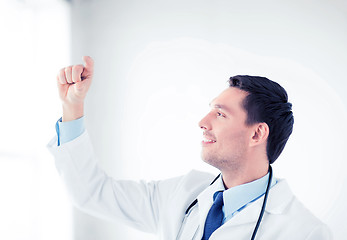 Image showing young doctor holding something imaginary