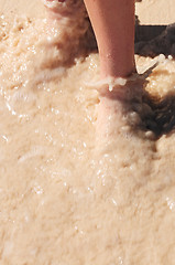 Image showing Feet washed in ocean wave