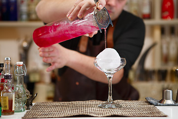 Image showing barman pouring a pink cocktail drink 