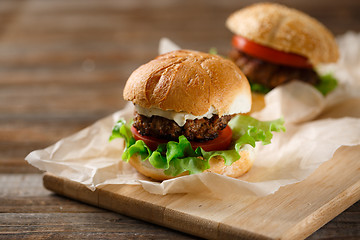 Image showing Homemade hamburgers and french fries on wooden table