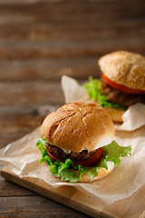 Image showing Homemade hamburgers and french fries on wooden table