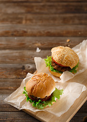 Image showing Homemade hamburgers and french fries on wooden table