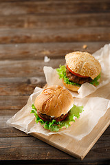 Image showing Homemade hamburgers and french fries on wooden table