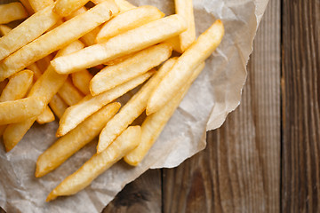 Image showing Fresh french fries on wooden background