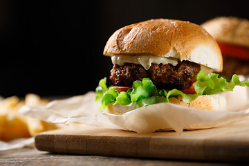 Image showing Homemade tasty burger and french fries on wooden table