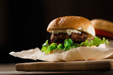 Image showing Homemade hamburgers and french fries on wooden table