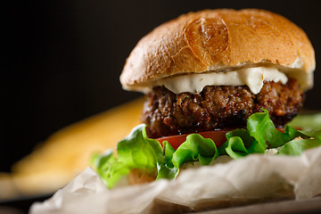 Image showing Homemade burger with french fries on wooden table