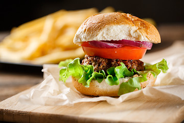 Image showing Homemade burger with french fries on wooden table