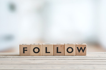 Image showing Follow sign on a wooden table