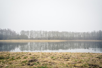 Image showing Misty lake with tree reflections