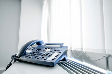 Image showing Telephone in an office window