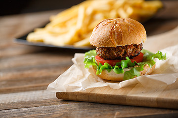 Image showing Homemade burger with french fries on wooden table