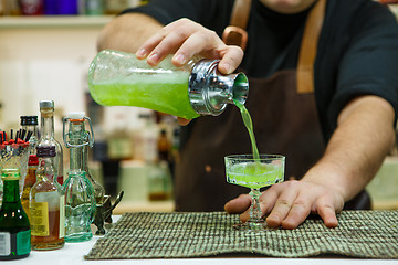 Image showing barman pouring a pink cocktail drink 