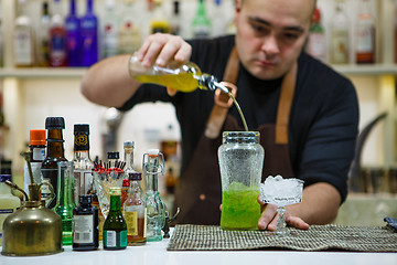 Image showing barman pouring a pink cocktail drink 