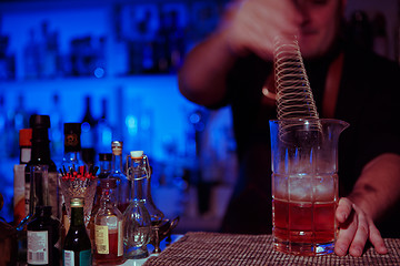 Image showing Bartender nixed cocktail in glass cup.