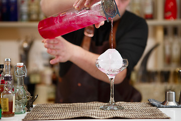 Image showing barman pouring a pink cocktail drink 