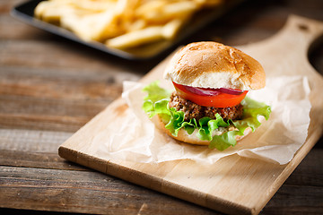 Image showing Homemade burger with french fries on wooden table