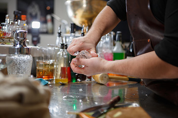Image showing Bartender pours alcoholic drink into small glasses with flames