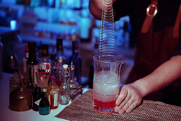 Image showing Bartender nixed cocktail in glass cup.