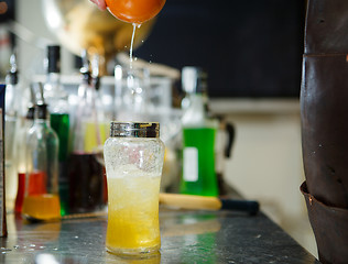 Image showing Bartender is straining cocktail in a glass