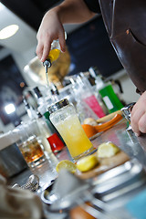 Image showing Bartender is straining cocktail in a glass