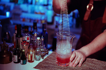 Image showing Bartender nixed cocktail in glass cup.