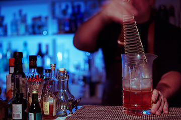 Image showing Bartender nixed cocktail in glass cup.