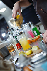 Image showing Bartender is straining cocktail in a glass