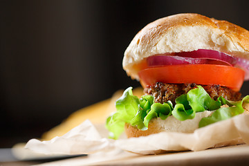 Image showing Homemade burger with french fries on wooden table