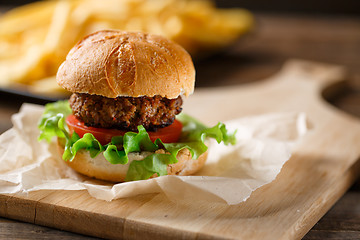 Image showing Homemade burger with french fries on wooden table