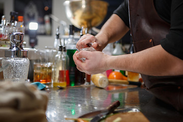 Image showing Bartender pours alcoholic drink into small glasses with flames