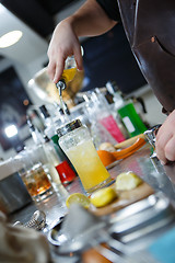 Image showing Bartender is straining cocktail in a glass