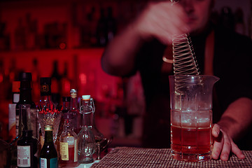 Image showing Bartender nixed cocktail in glass cup.