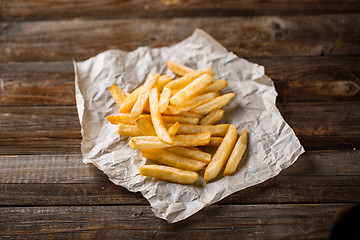 Image showing French fries on wooden table.