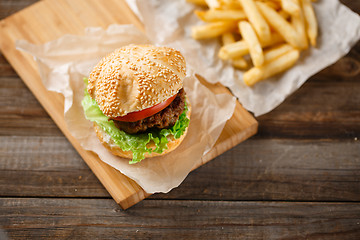 Image showing Homemade hamburgers and french fries on wooden table