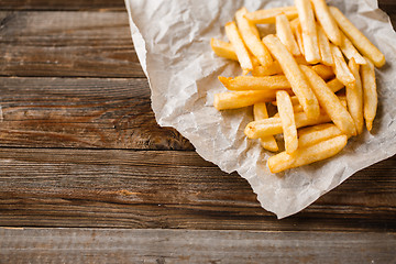 Image showing French fries on wooden table.