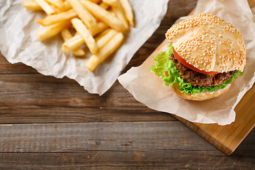 Image showing Homemade hamburgers and french fries on wooden table