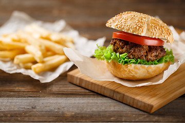 Image showing Homemade hamburgers and french fries on wooden table