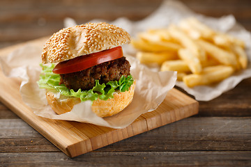 Image showing Homemade hamburgers and french fries on wooden table