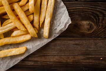 Image showing French fries on wooden table.