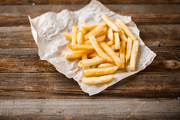 Image showing French fries on wooden table.