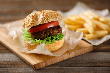 Image showing Homemade hamburgers and french fries on wooden table