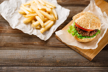 Image showing Homemade hamburgers and french fries on wooden table