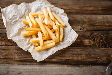 Image showing French fries on wooden table.