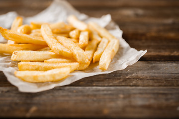 Image showing French fries on wooden table.